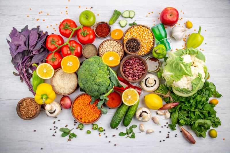 top-view-fresh-foods-spices-vegetables-cooking-white-table selection of colourful plant foods